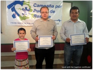 Sarah holding her baptism certificate along with brother Miguel and brother Cesar